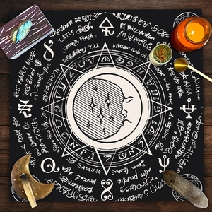 Close-up of black velvet tarot cloth with mystical sun, moon, and astrological symbols