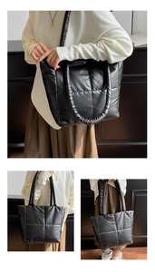 Detail view of black padded tote bag with large square quilting and glossy finish