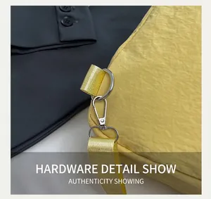 Detailed close-up of the silver metal lobster clasp and yellow nylon strap on the bag