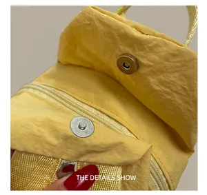 Detail of yellow nylon backpack featuring magnetic closure and internal zipper pocket