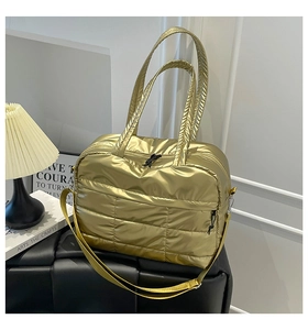 Detail der goldenen Stepptasche mit Metallic-Textur und verstellbarem Schultergurt