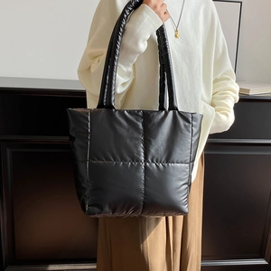 Minimalist black quilted down tote bag with soft padded handles for daily commute