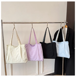 Detail view of large capacity canvas tote bags in cream, purple, black and sky blue