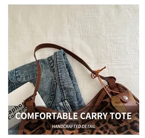 Detail of leopard print tote bag featuring brown leather handles and soft velvet texture