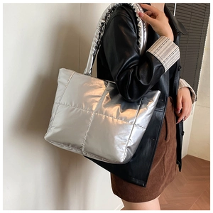 Detail of the silver metallic quilted tote bag with padded texture and wide shoulder strap