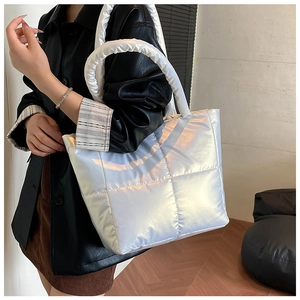 Close-up of a silver puffer tote bag with quilted pattern and unique cloud strap