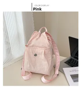 Detail of pink nylon drawstring backpack featuring magnetic pocket and side zipper