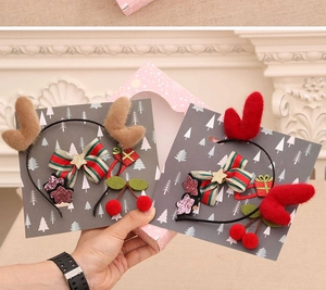 Detailed view of Christmas reindeer antler headbands with festive bows and glitter stars