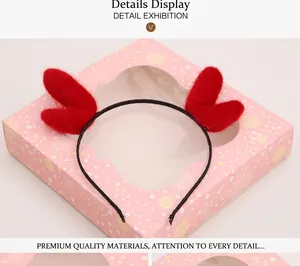 Detail view of red heart plush headband with pink snowflake pattern gift box packaging