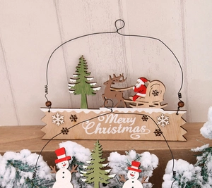 Detail of wooden Merry Christmas hanging sign with hand-painted Santa and reindeer motifs