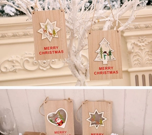 Dettaglio di pendenti natalizi in legno con renna e scritta Merry Christmas