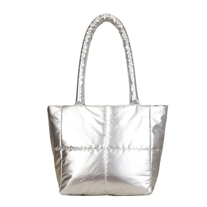 Metallic silver quilted down tote bag with a glossy finish and long shoulder strap