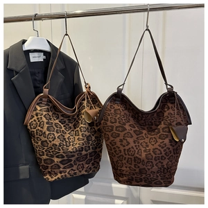 Detail of leopard print bucket bags in two tones paired with a retro black blazer