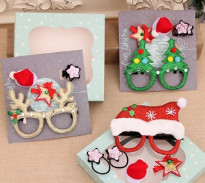 Detailed view of Christmas glasses and hair clip sets with glitter deer antlers and trees