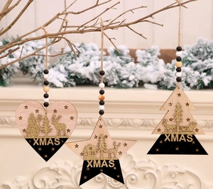 Détail de décorations de Noël en bois avec paillettes noires et dorées sur branche