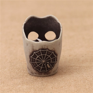 Close-up of vintage ceramic Halloween candle holder with spider web and hollow design