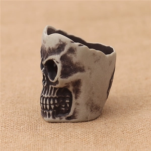 Macro detail of gothic skull-shaped LED candle holder with aged texture and deep carving