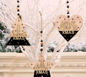 Détail de suspensions de Noël en bois noir et or sur des branches blanches décoratives