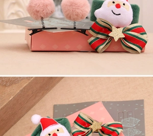 Détail macro du lot de barrettes de Noël avec peluche Père Noël et nœud ruban en coffret