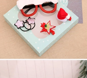 Detailed view of Christmas accessory set including glitter glasses and hair clips in gift box