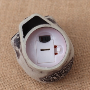 Detail view of the battery compartment and power switch on the Halloween skull light