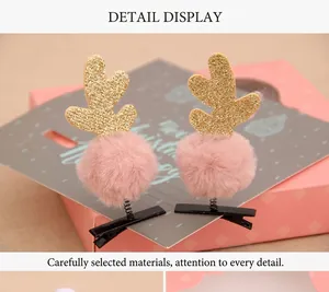 Détail de pinces à cheveux bois de renne dorés scintillants et pompons roses en fourrure