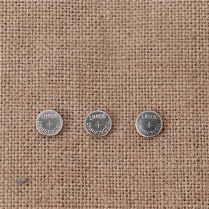 Detailed view of three LR1130 mercury-free button cell batteries for LED props