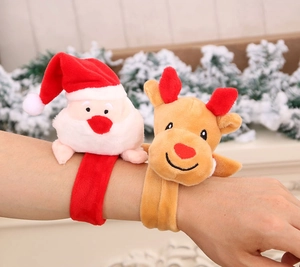 Detail of plush Santa and reindeer snap bracelets worn on arm with festive decor