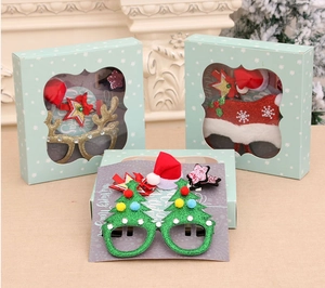 Close-up of Christmas party favors set with glitter glasses and hair clips in a gift box