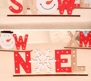 Dettaglio di lettere natalizie in legno SNOW e NOEL con decorazioni di pupazzi di neve e stelle