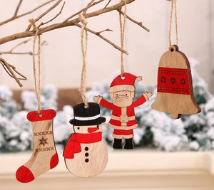 Primer plano de adornos navideños de madera pintada colgados en una rama rústica