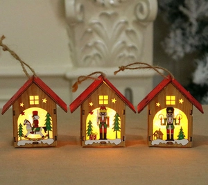 Three illuminated wooden Christmas house pendants with nutcracker scenes and warm LED lights