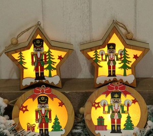 Dettaglio di quattro ornamenti schiaccianoci in legno a LED con luce calda su pini innevati