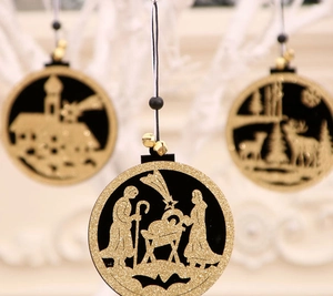Detail van lasergesneden houten kerstversieringen met gouden glitters en diverse motieven