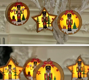 Dettaglio di pendente natalizio in legno Schiaccianoci con luce LED calda e fiocco rosso