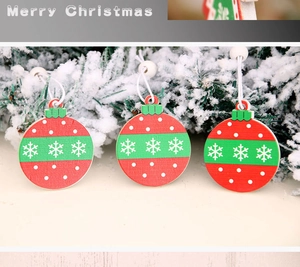 Detailed view of red wooden Christmas ornaments with white snowflakes on snowy pine branch