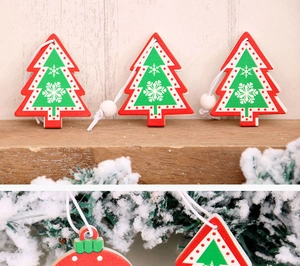 Detailed view of wooden Christmas tree and ball ornaments hanging on snowy pine branches
