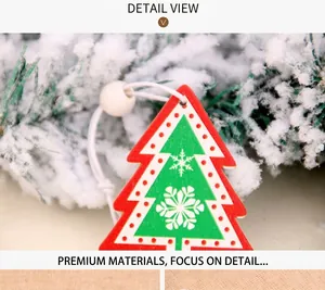 Detail of wooden Christmas tree ornament with snowflake pattern on pine branches