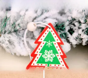 Detail of wooden Christmas tree ornament with snowflake pattern on pine branches