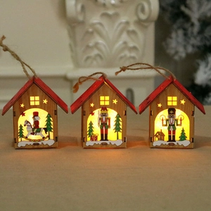 Three glowing wooden Christmas house pendants with Nutcracker prints and warm LED lights