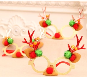 Detail of Christmas reindeer antler glasses with gold glitter finish and plush pom poms