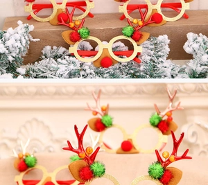 Close-up of glittery gold Christmas antler glasses with red felt ears and plush pom-poms