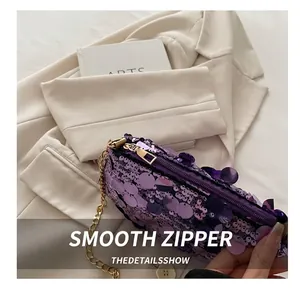 Detail of purple sequin handbag with gold chain on a beige blazer background