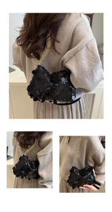 Detailed view of shimmering black sequin handbag with elegant gold chain strap