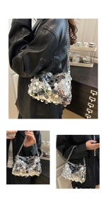 Detail of silver sequin shoulder bag with metal chain strap and reflective finish