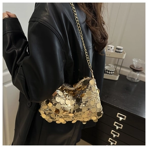 Detail of shimmering gold sequins and metallic chain strap on a stylish shoulder bag