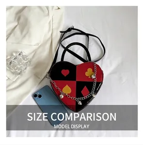 Close-up of heart-shaped handbag with poker suit prints and metallic chain detail