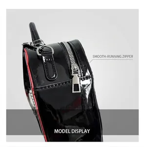 Detail of smooth silver zipper and red contrast edge on black patent leather heart bag