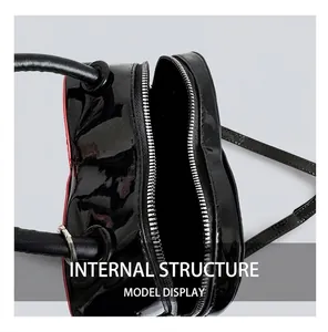 Top view of heart-shaped black crossbody bag showing internal storage and double zippers