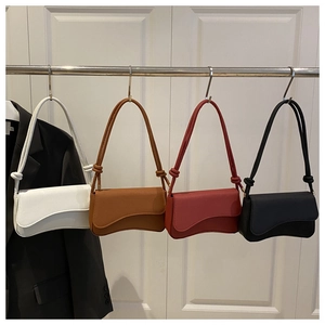 Detailed view of structured leather crossbody bags in four colors with knot strap detail